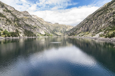 Scenic view of lake by mountains against sky