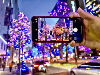 People photographing illuminated cityscape at night