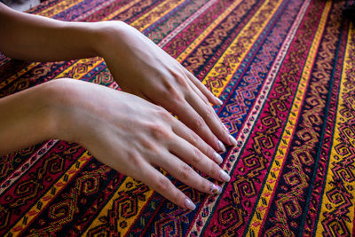 Cropped hands of woman touching patterned fabric