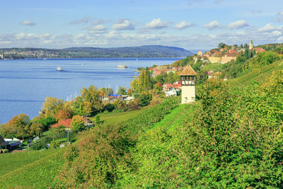 Scenic view of sea by buildings against sky