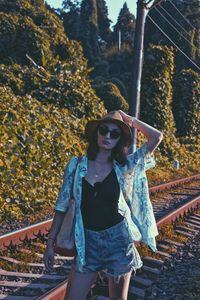 Portrait of young woman standing against trees during autumn