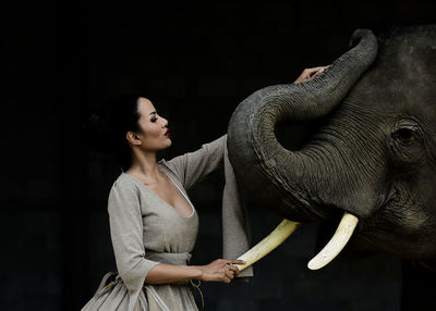 Young woman standing by elephant