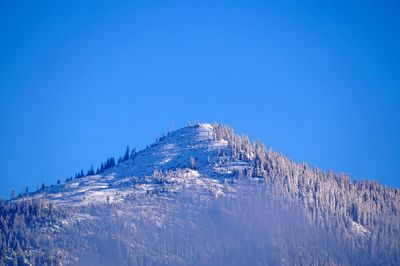 Scenic view of snowcapped mountain against blue sky