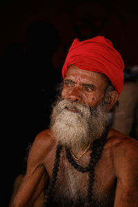 Portrait of man wearing hat against black background