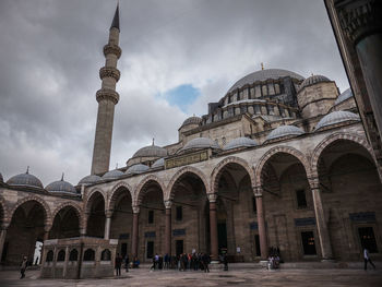 Group of people in front of historic building against sky