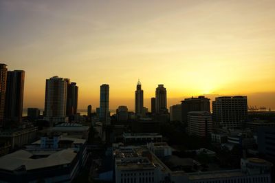 Modern buildings against sky during sunset