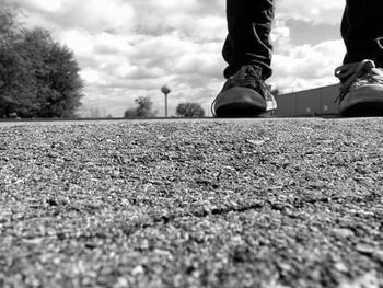 Low section of person standing on road