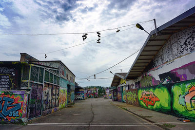 Graffiti on wall by street against sky