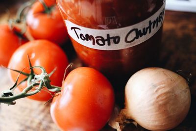 Close-up of tomatoes and onion by bottle with label