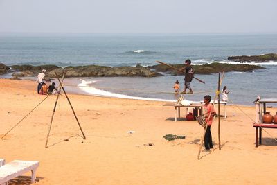 People on beach against clear sky