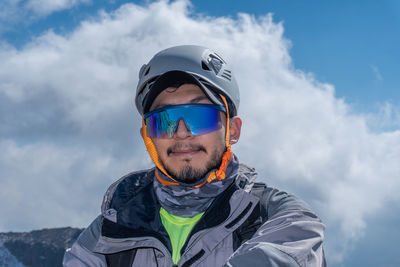 Portrait of young man standing against sky