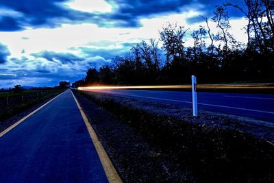 Empty road against cloudy sky
