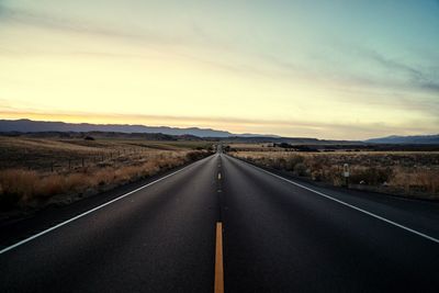 Empty road along countryside landscape