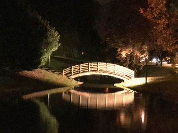 Arch bridge over lake at night