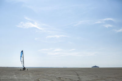 Denmark, romo, land yacht on coastal beach with ferry in distant background