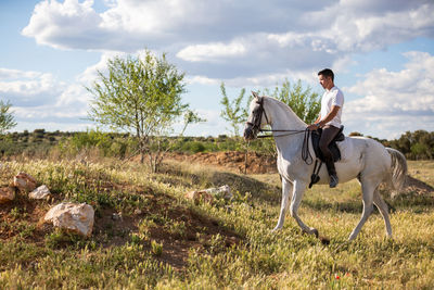 Man riding horse against sky