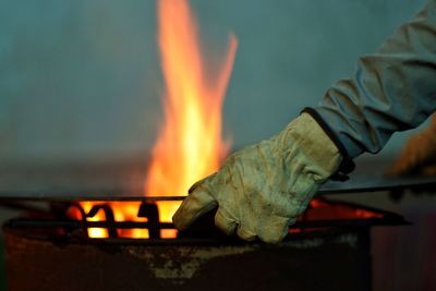 Close-up of hand holding burning fire at night