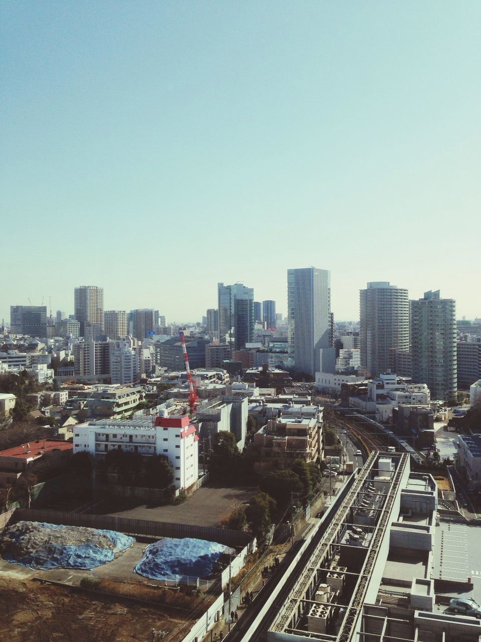 architecture, building exterior, built structure, city, city life, transportation, large group of people, street, high angle view, residential building, travel destinations, sky, travel, tower, incidental people, clear sky, mode of transport, famous place, building