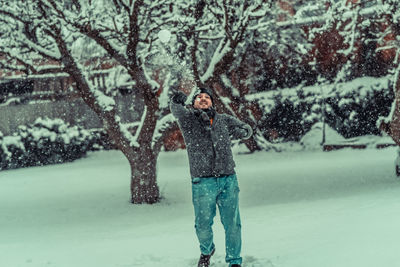 Full length of person standing on snow covered tree