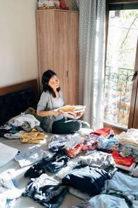 Young woman sitting on table at home