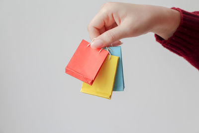 Cropped hand holding toy blocks against white background