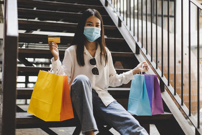 Portrait of woman sitting in front of building