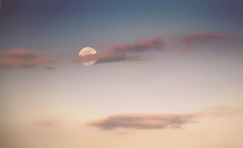 Low angle view of moon in sky at sunset