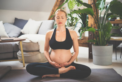 Pregnant woman meditating at home