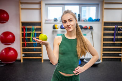 Portrait of young woman exercising in gym