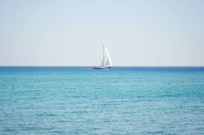 Sailboat in sea against clear sky