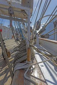 Close-up of rope tied on metallic structure against sky