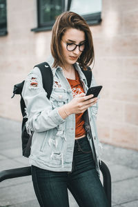 Full length of young woman using mobile phone