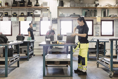 Side view of female high school student working on project in training class