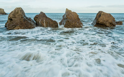 Rocks in sea against sky