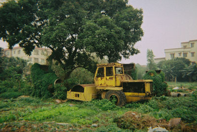 Tractor and trees against built structure