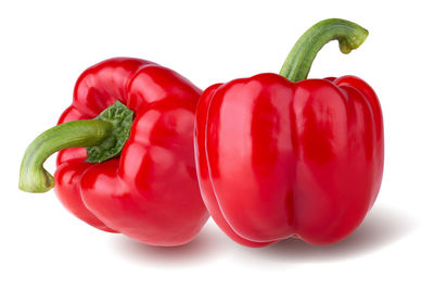 Close-up of red bell peppers against white background