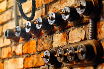 Close-up of old bells on brick wall