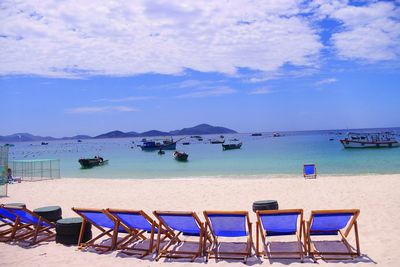 Chairs on beach against sky