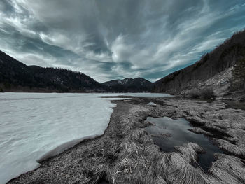 Scenic view of lake by mountains against sky