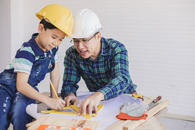 Engineer assisting son in making drawing