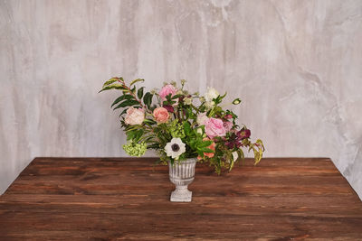 Flower vase on table against wall