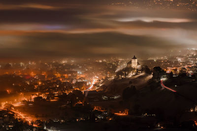 High angle view of illuminated cityscape against sky at sunset