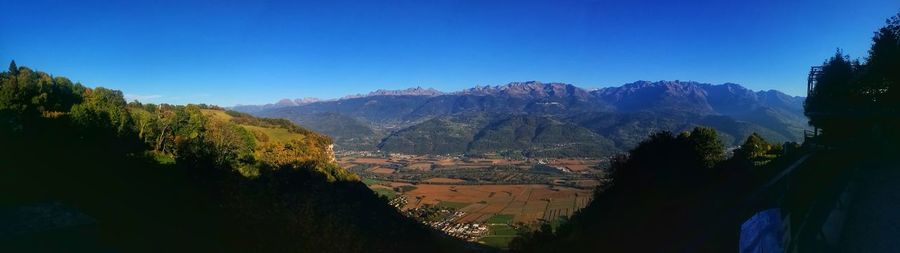 Panoramic view of landscape and mountains against blue sky