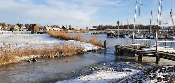 Scenic view of harbor against sky during winter