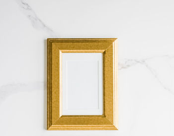 Directly above shot of blank picture frame against white background