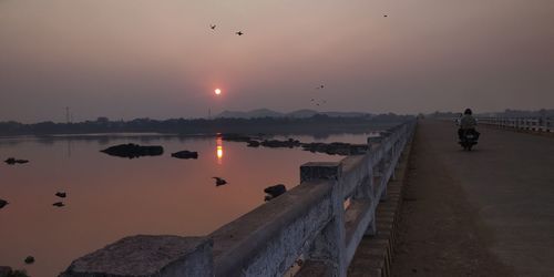 Scenic view of river mahanadi against sky during sunset