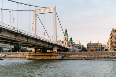 Suspension bridge over river against sky