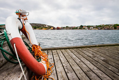 Life belt on boat deck sailing in sea against sky