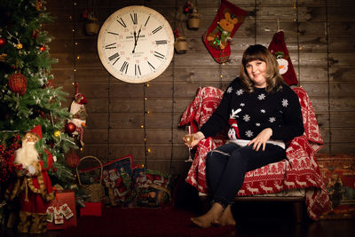 Full length of young woman sitting on wall