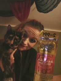 Close-up portrait of smiling young woman with cat